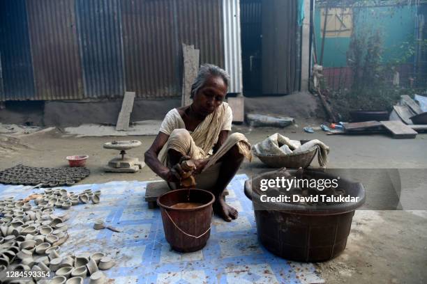 woman potter makes earthen lamps ahead of diwali - an artist makes earthen lamps for diwali festival stock pictures, royalty-free photos & images