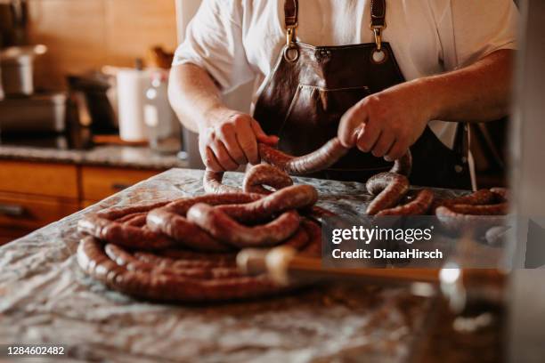 mann bereitet seine eigenen hausgemachten würstchen zu hause - butchery stock-fotos und bilder