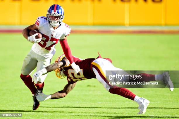 Sterling Shepard of the New York Giants runs with the ball while being tackled by Deshazor Everett of the Washington Football Team in the second...