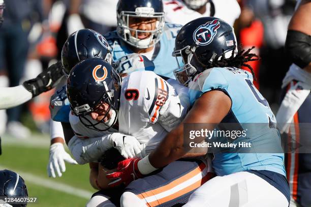 Jayon Brown and Larrell Murchison of the Tennessee Titans combine to tackle Nick Foles of the Chicago Bears during the second quarter at Nissan...