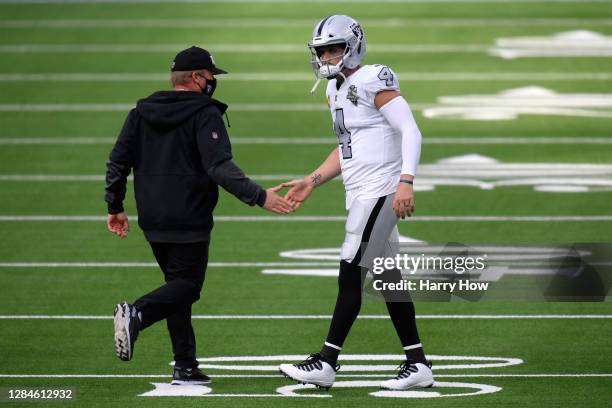 Head coach Jon Gruden of the Las Vegas Raiders shakes hands with Derek Carr prior to playing the Los Angeles Chargers at SoFi Stadium on November 08,...