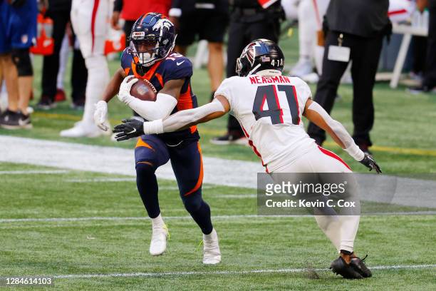 Hamler of the Denver Broncos runs with the ball against Sharrod Neasman of the Atlanta Falcons during the second half at Mercedes-Benz Stadium on...