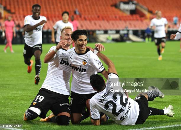 Carlos Soler of Valencia celebrates with teammates after scoring his team's third goal during the La Liga Santander match between Valencia CF and...
