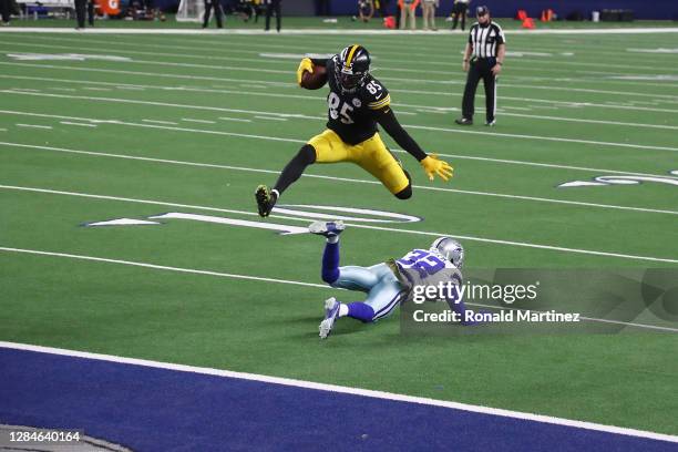 Eric Ebron of the Pittsburgh Steelers leaps over Saivion Smith of the Dallas Cowboys during the second half at AT&T Stadium on November 08, 2020 in...