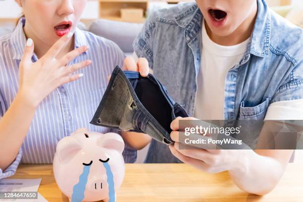 asian couple blow their money - couple saving piggy bank stock pictures, royalty-free photos & images