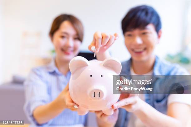 couple show their piggy bank - couple saving piggy bank stock pictures, royalty-free photos & images