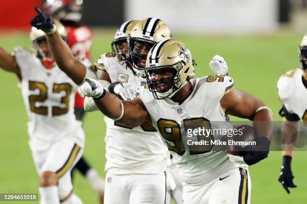 David Onyemata of the New Orleans Saints celebrates with teammates after intercepting a pass during the second quarter against the Tampa Bay...