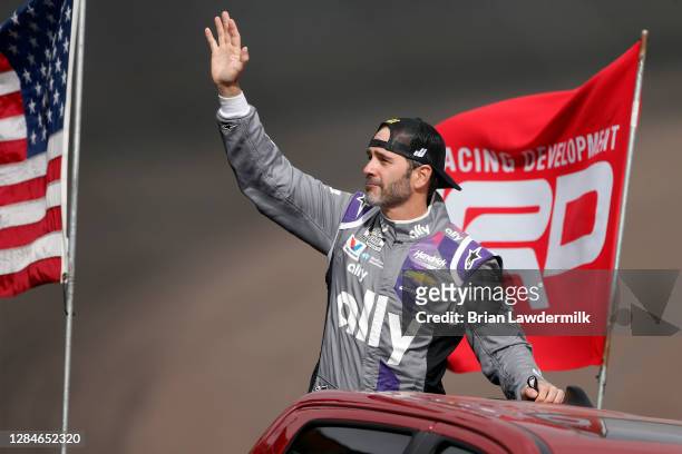 Jimmie Johnson, driver of the Ally Chevrolet, waves to fans as he is driven on the track during pre-race ceremonies prior to the NASCAR Cup Series...