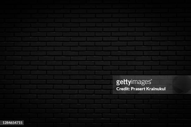 black brick wall. background of empty brick basement wall - zwarte kleur stockfoto's en -beelden