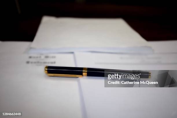 last will & testament & other estate planning documents on wooden desk under pen - coroner stock pictures, royalty-free photos & images