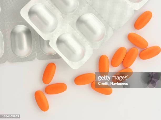 orange medicine and silver color capsule package on white background - vitamin sachet stock pictures, royalty-free photos & images