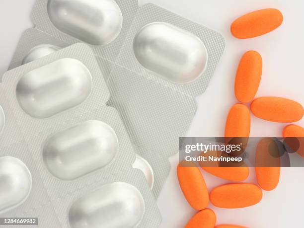 orange medicine and silver color capsule package on white background - vitamin sachet stock pictures, royalty-free photos & images