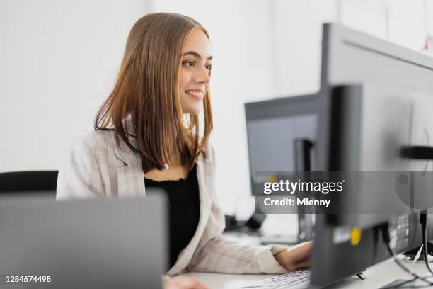 gelukkige glimlachende vrouw in modern bureau dat e-mail leest - apprentice office stockfoto's en -beelden