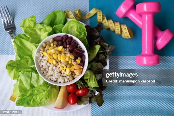 workout and fitness dieting copy space diary. healthy lifestyle concept. dumbbell, vegetable salad and measuring tape on rustic wooden table - gewicht verlieren stock-fotos und bilder