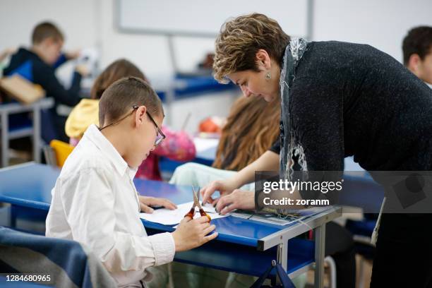 female teacher working with a special need elementary age boy - learning disability stock pictures, royalty-free photos & images