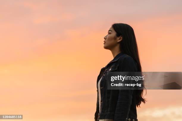 日没時の自然の中の若い女性の肖像 - looking up ストックフォトと画像