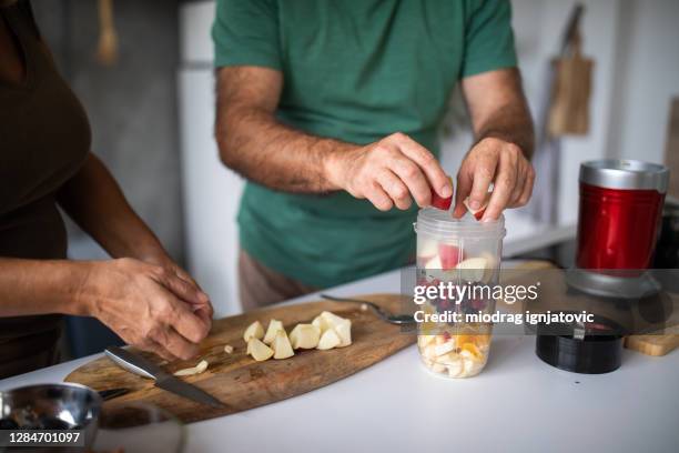 hoger paar dat verse smoothie thuis voorbereidt - besparen stockfoto's en -beelden