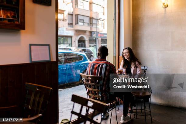 happy young woman with boyfriend in cafe - dating stock-fotos und bilder