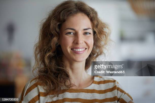 beautiful woman smiling while standing at home - 35 year old woman stock pictures, royalty-free photos & images