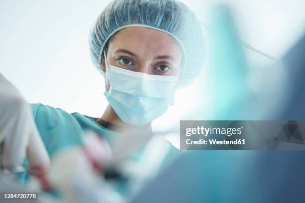 confident female surgeon operating in intensive care unit at hospital - critical care stock pictures, royalty-free photos & images