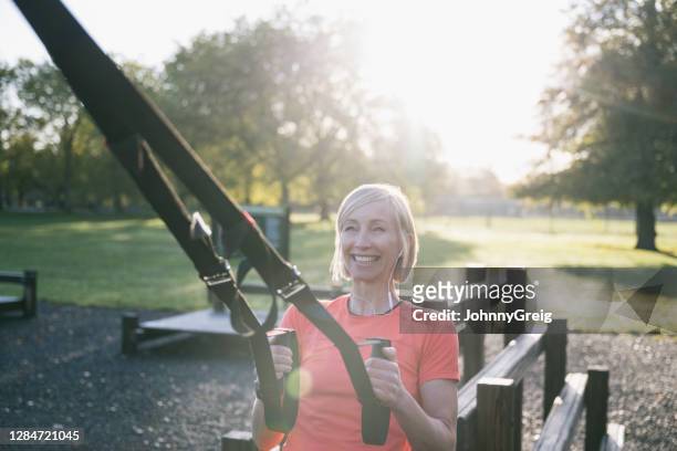 action portrait of female athlete doing suspension pull-up - suspension training stock pictures, royalty-free photos & images