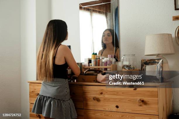 teenage girl looking in mirror while standing at home - girl in mirror stock pictures, royalty-free photos & images