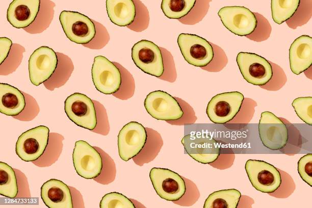 pattern of halved avocados - obst stock-grafiken, -clipart, -cartoons und -symbole