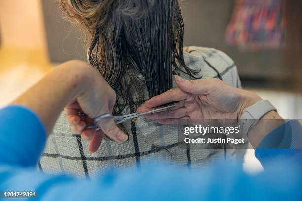 woman cutting her senior mother's hair at home - lockdown haircut stock pictures, royalty-free photos & images