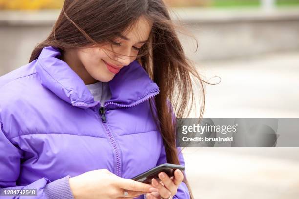 portrait of 17 year old teen girl with long brown hair - purple jacket stock pictures, royalty-free photos & images