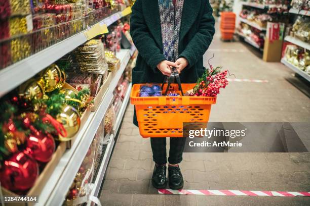 social distancing on christmas shopping during covid-19 - supermarket queue stock pictures, royalty-free photos & images