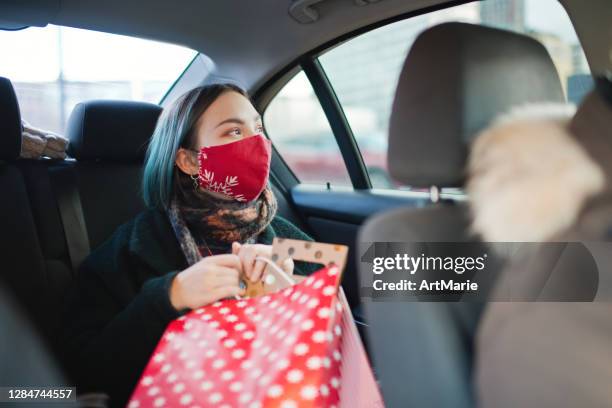 tiener die beschermend gezichtsmasker in auto na het winkelen van kerstmis tijdens covid-19 pandemie draagt - christmas driving stockfoto's en -beelden