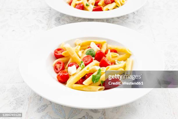 plate of vegetarian pasta withmozzarella, cherry tomatoes and basil - pasta tomato basil stock pictures, royalty-free photos & images