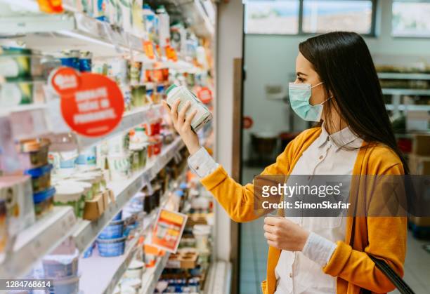 frau kauft während der pandemie milchprodukte ein - food safety stock-fotos und bilder