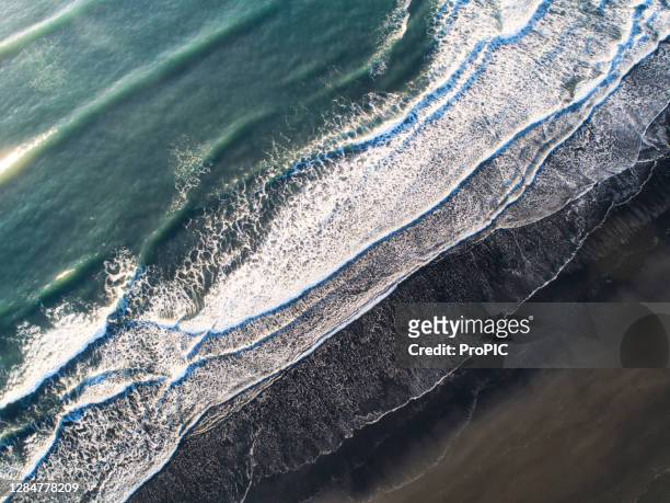 reynisfjara black sand beach is a beautiful black sand beach on the island of iceland.beautiful aerial views using a drone. - cliff texture stockfoto's en -beelden