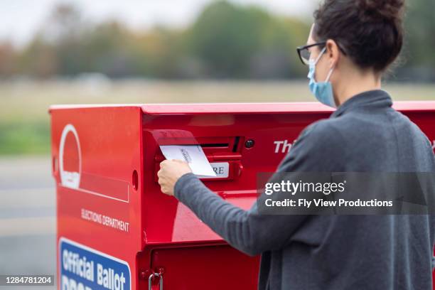 young adult mixed race woman voting at ballot box - woman president stock pictures, royalty-free photos & images