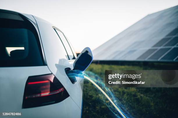 carga de coche eléctrico en la central eléctrica. transmisión de potencia electic a través de un cable. - solar powered station fotografías e imágenes de stock