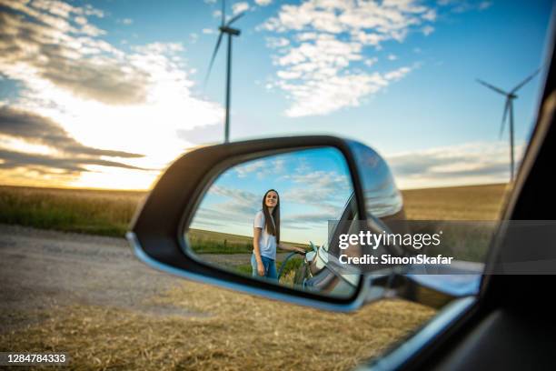 reflexion einer frau, die elektroauto sauft - electric vehicle stock-fotos und bilder