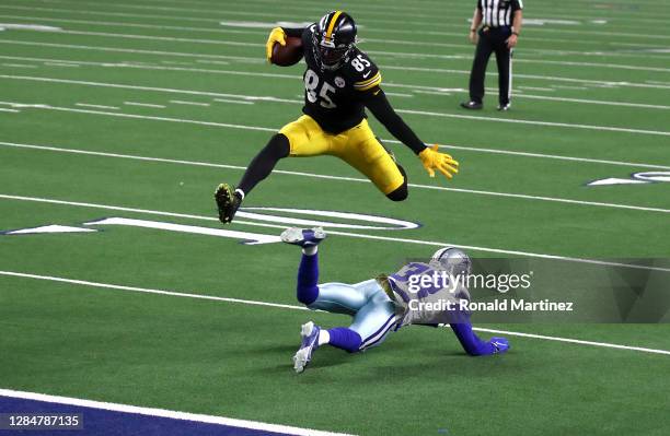 Eric Ebron of the Pittsburgh Steelers leaps over Saivion Smith of the Dallas Cowboys during the second half at AT&T Stadium on November 08, 2020 in...
