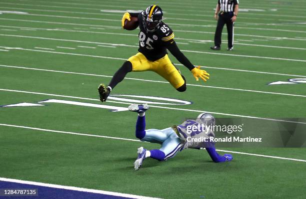 Eric Ebron of the Pittsburgh Steelers leaps over Saivion Smith of the Dallas Cowboys during the second half at AT&T Stadium on November 08, 2020 in...