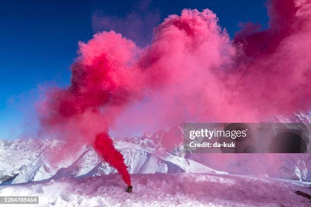smoke bomb with red smoke in the mountains - smoke bomb stock pictures, royalty-free photos & images