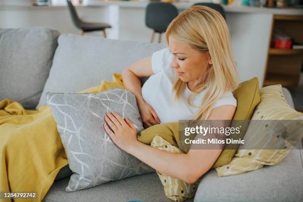 mujer con las manos en el estómago que sufre de dolor stock foto - ovarios fotografías e imágenes de stock