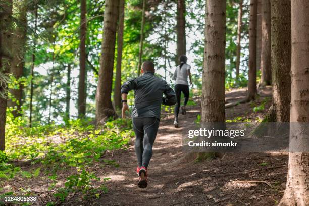 jogging d’homme et de femme dans la forêt - man in running tights photos et images de collection