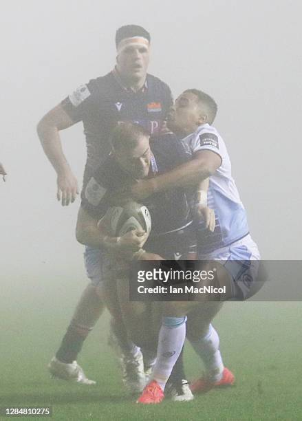 Nathan Chamberlin of Edinburgh is tackled by Ben Thomas of Cardiff Blues during the Guinness PRO14 match between Edinburgh Rugby and Cardiff Blues at...