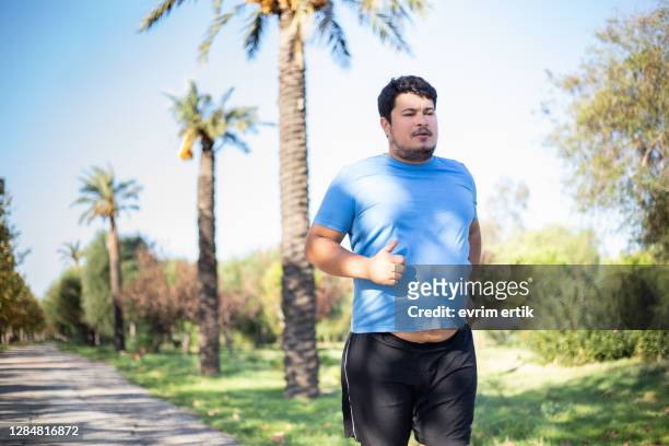 overweight man running for weight loss - fat loss training stock pictures, royalty-free photos & images