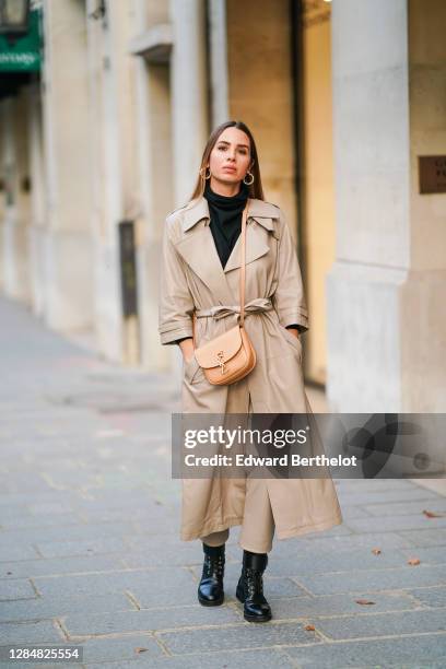 Maria Rosaria Rizzo wears a beige trench coat from Zeynep Arcay, a Saint Laurent YSL beige bag, a black turtleneck wool pullover, pale brown leather...