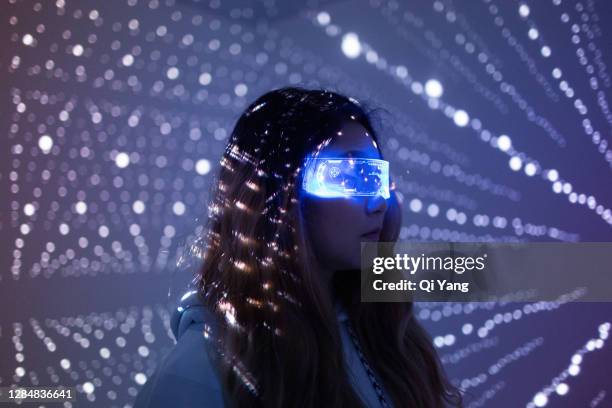 woman wearing augmented reality glasses at night - digital eye stockfoto's en -beelden