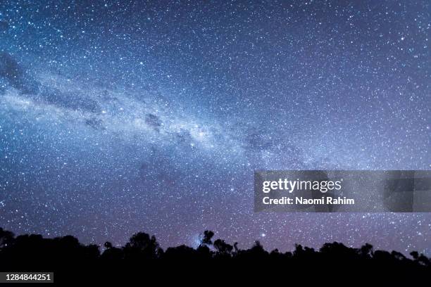 vivid milkyway surrounded by billions of stars in the night sky in australia - solsticio de invierno fotografías e imágenes de stock