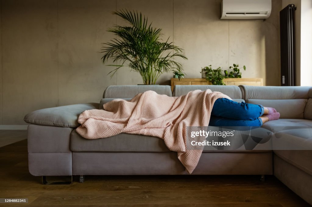 Mujer joven durmiendo bajo la manta