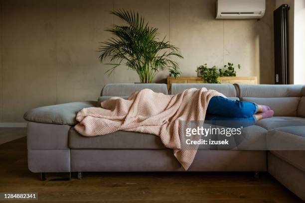 young woman sleeping under blanket - pandemic illness imagens e fotografias de stock