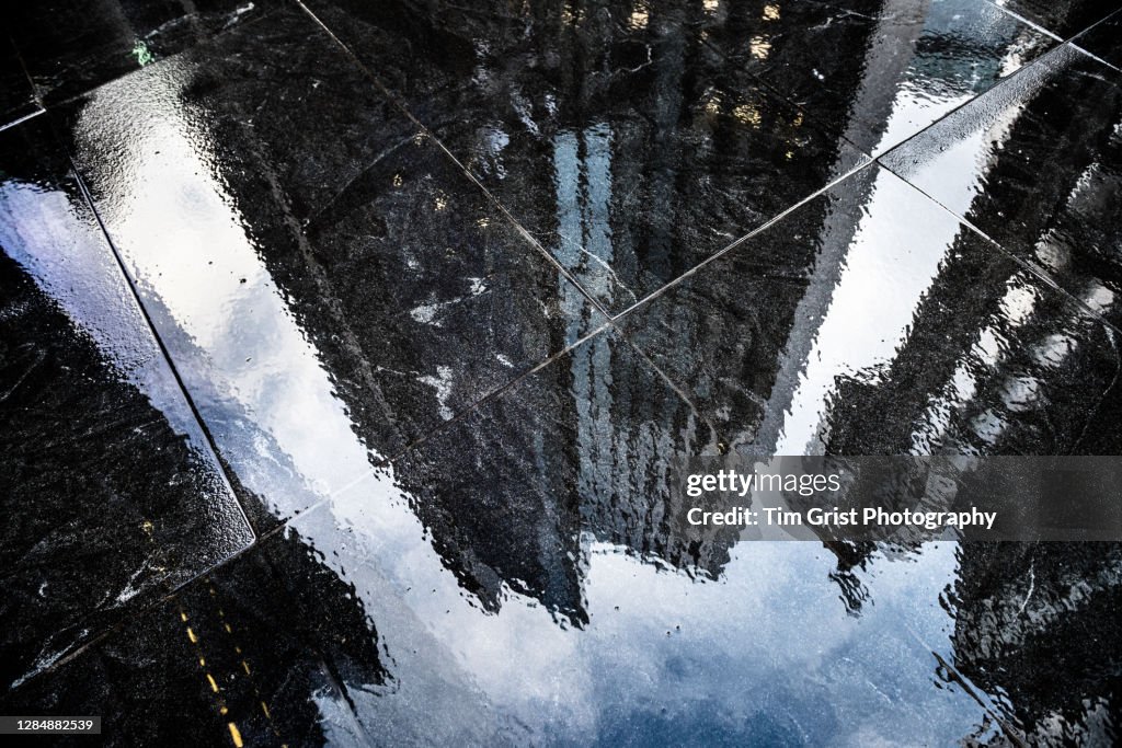 Reflections in the Wet Sidewalk of Modern Office Skyscrapers in The City of London